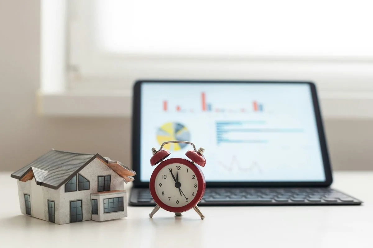 Maison en jouet et tablette illustrant l'investissement immobilier